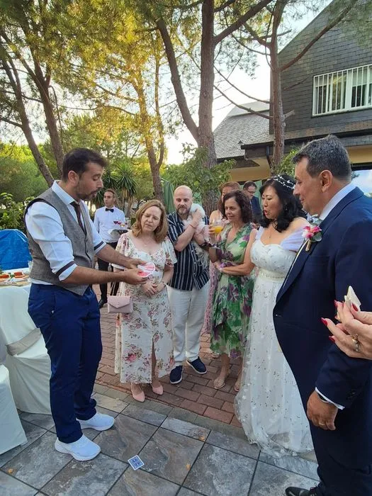 Mago de bodas haciendo magia itinerante con los invitados en el jardín